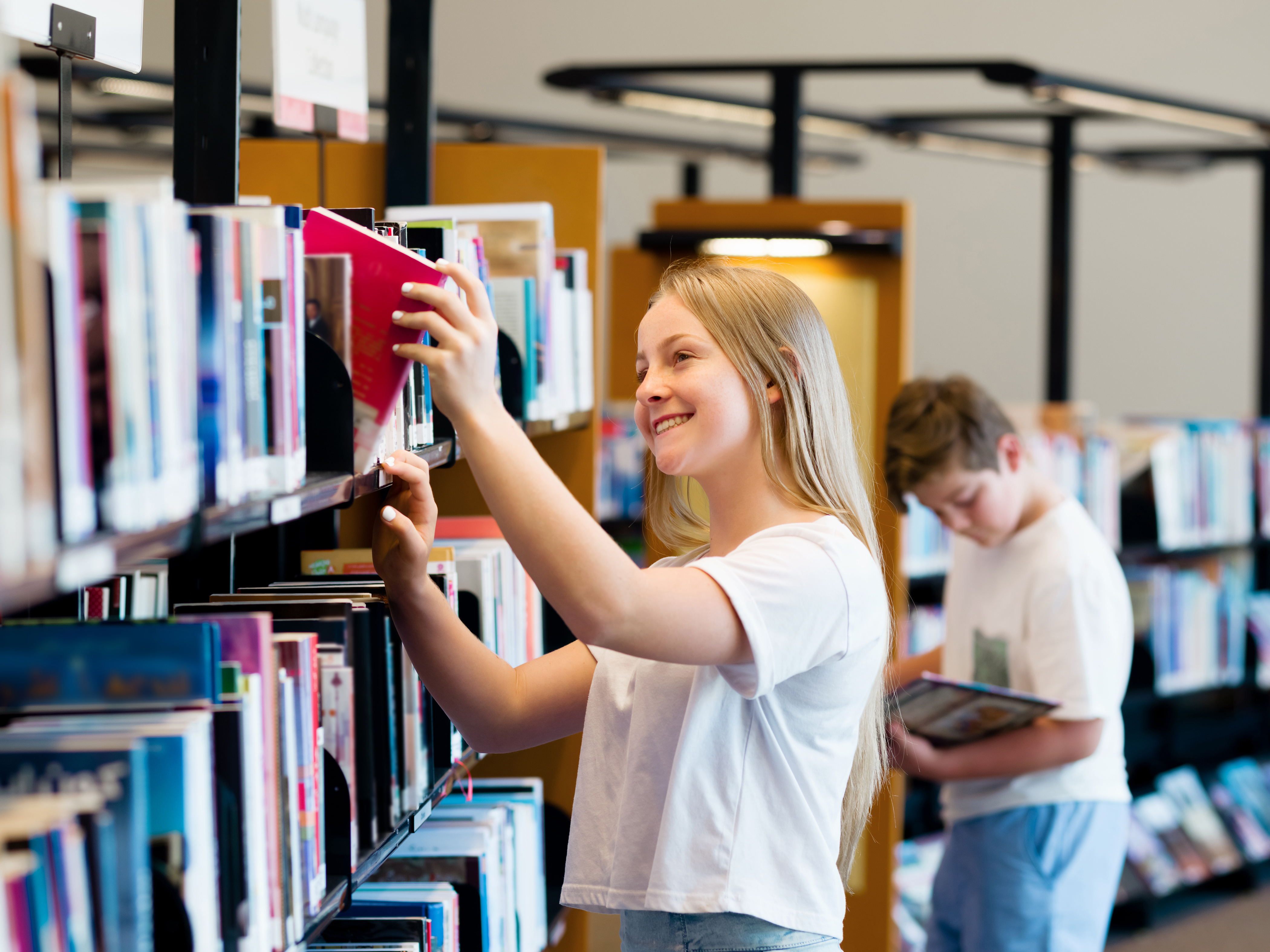 Купить книгу выборы. Подростки в библиотеке. Девушка выбирает книгу. Подросток с книгой. Подросток выбирает книгу.